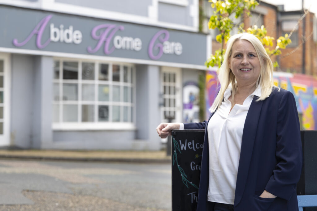 Helen, Founder and Managing Director, standing outside the Abide Home Care office.